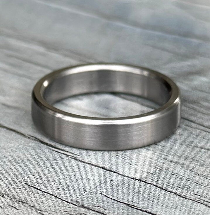 Brushed titanium ring photographed at an angle showing low satin sheen