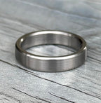 Brushed titanium ring photographed at an angle showing low satin sheen
