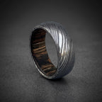 Domed Damascus steel wedding band photographed at an angle