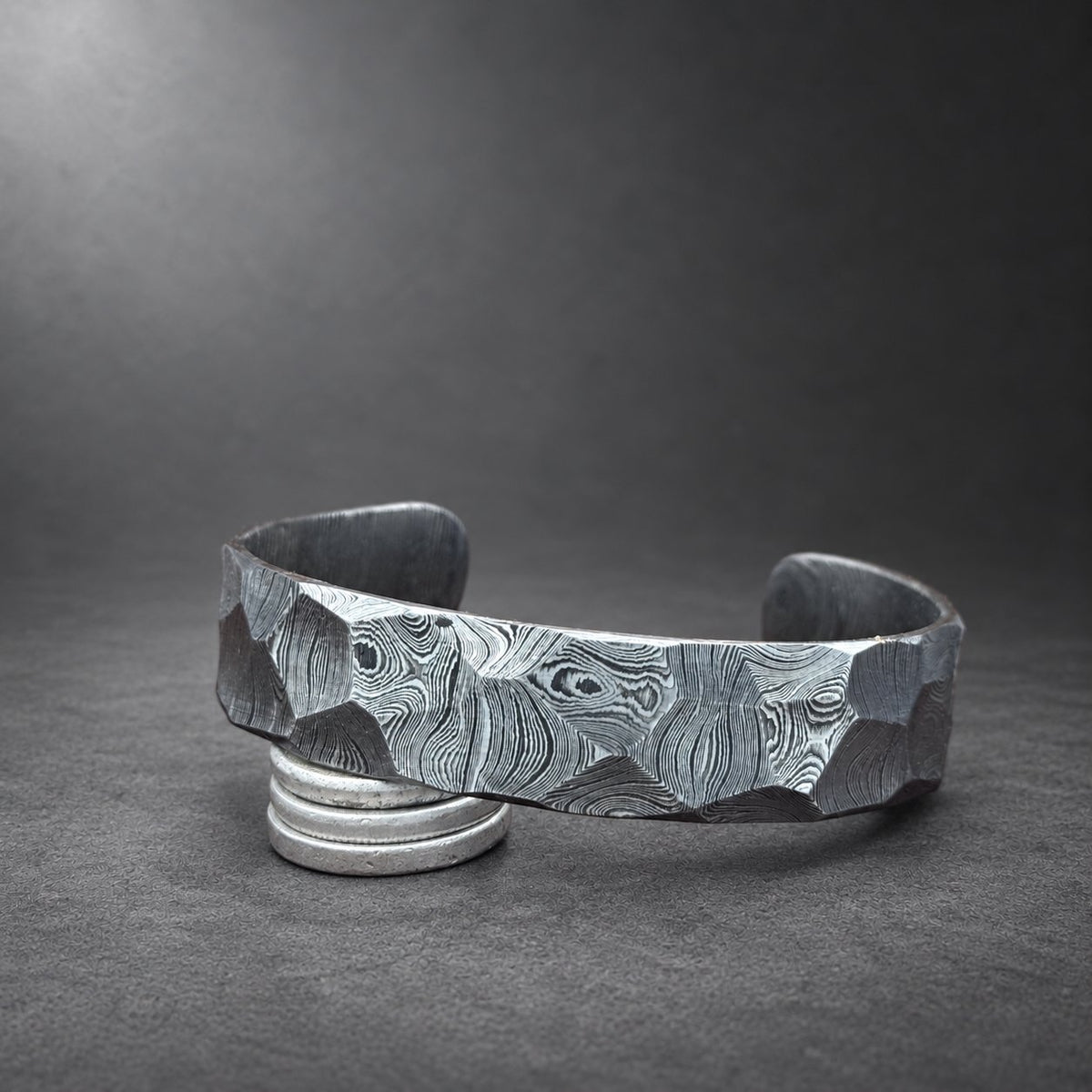 Hammered Damascus steel cuff bracelet photographed at an angle