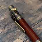 Damascus steel pen showing etched grain pattern and copper accent