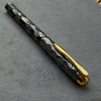 Damascus steel fountain pen photographed at an angle on dark surface