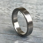 Close-up of brushed titanium ring showing satin single-direction finish