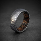 Close-up of dark wood inlay inside domed Damascus steel wedding band