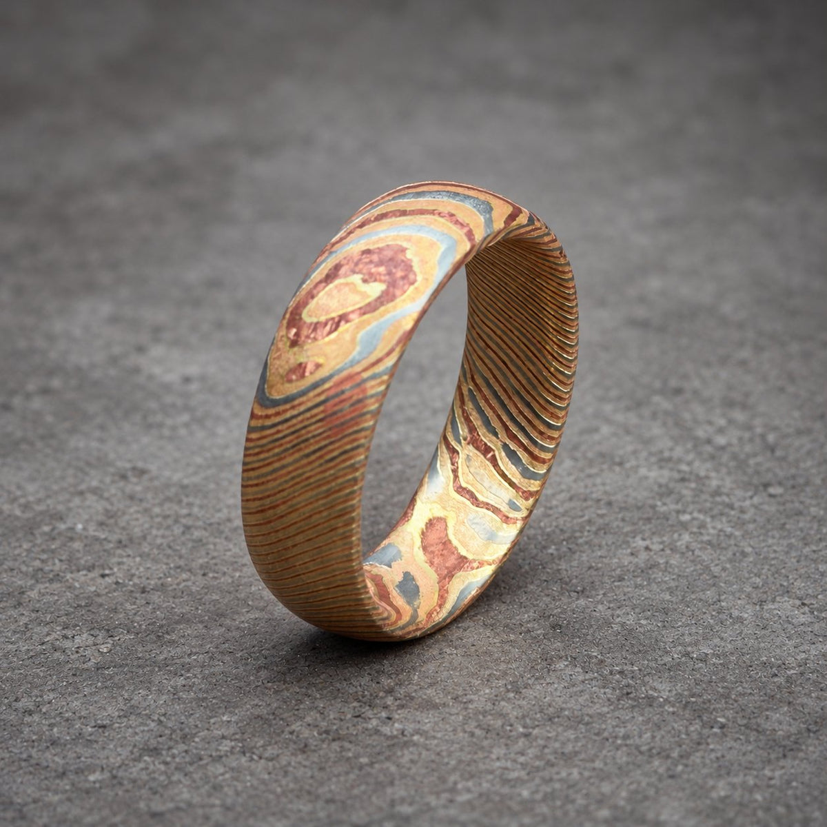 Mokume gane ring photographed at an angle showing surfaced sheet pattern