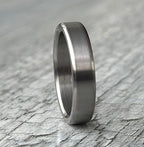 Brushed titanium wedding band worn on hand, minimalist engagement ring