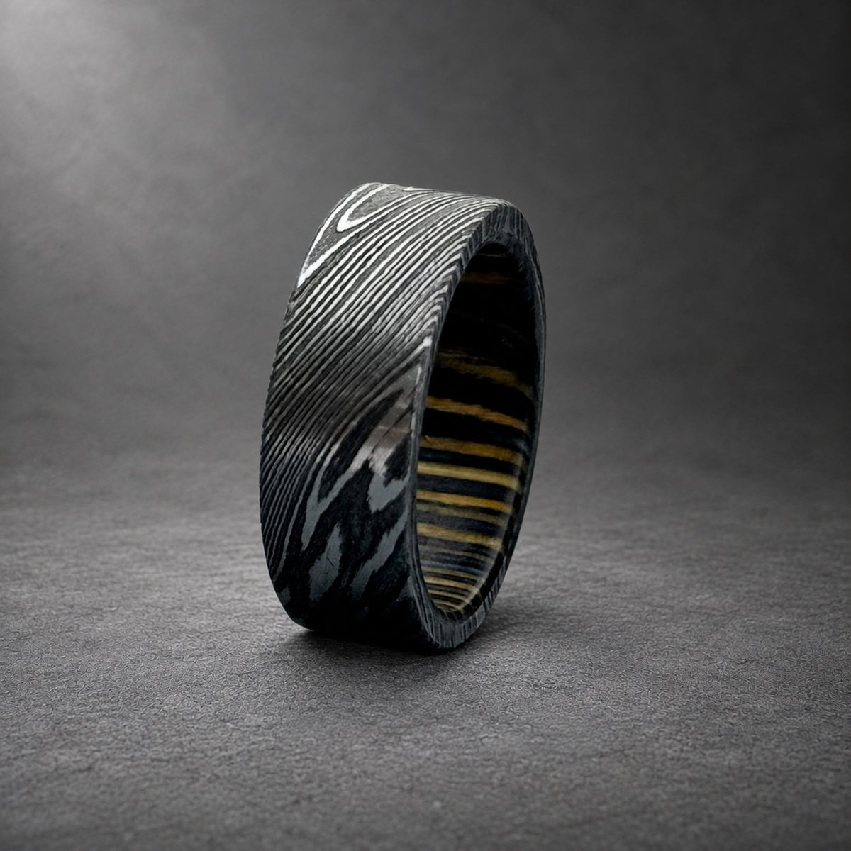 Damascus steel ring with dark wine barrel wood inlay, side view