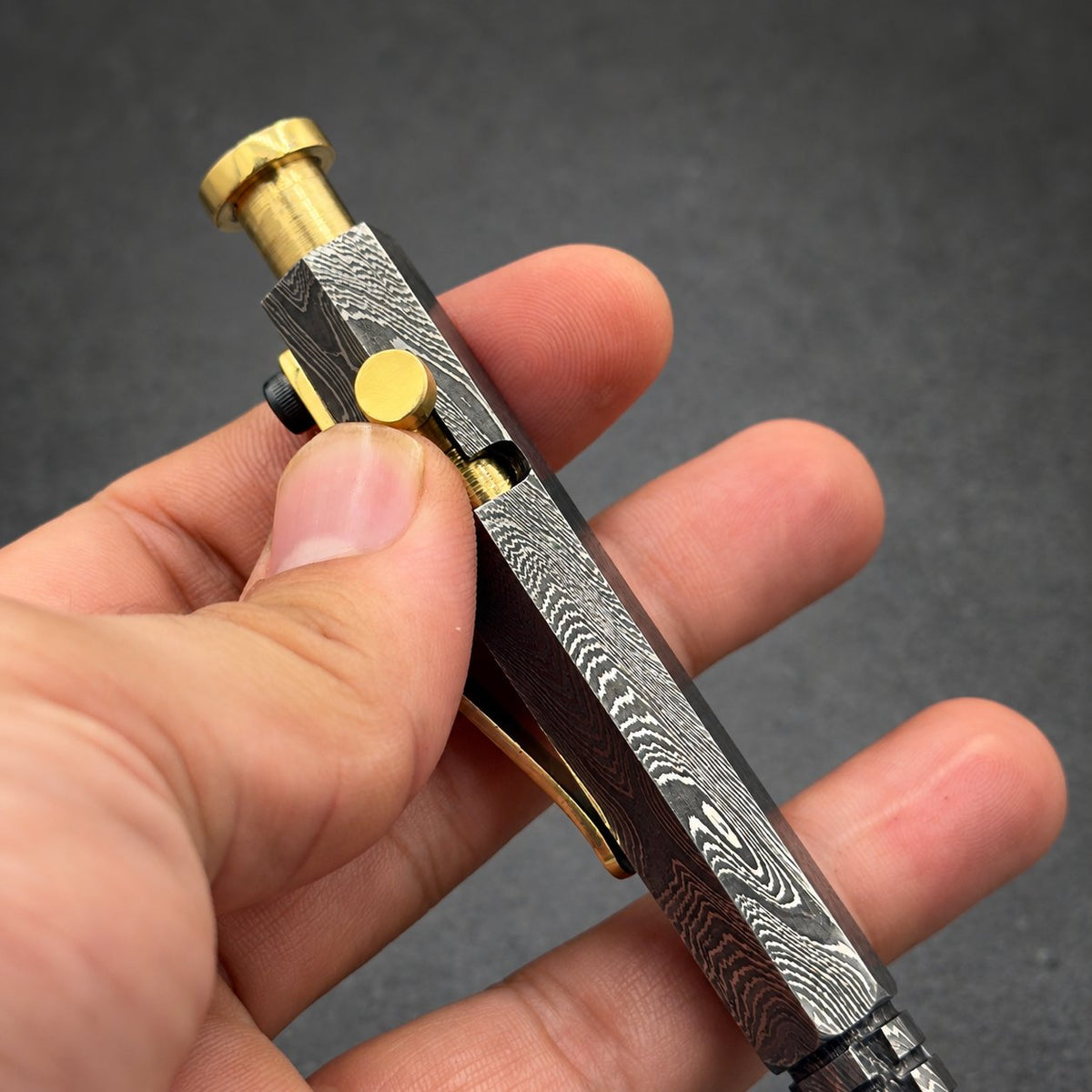 Close-up of hexagonal Damascus steel pen showing knurled grip texture