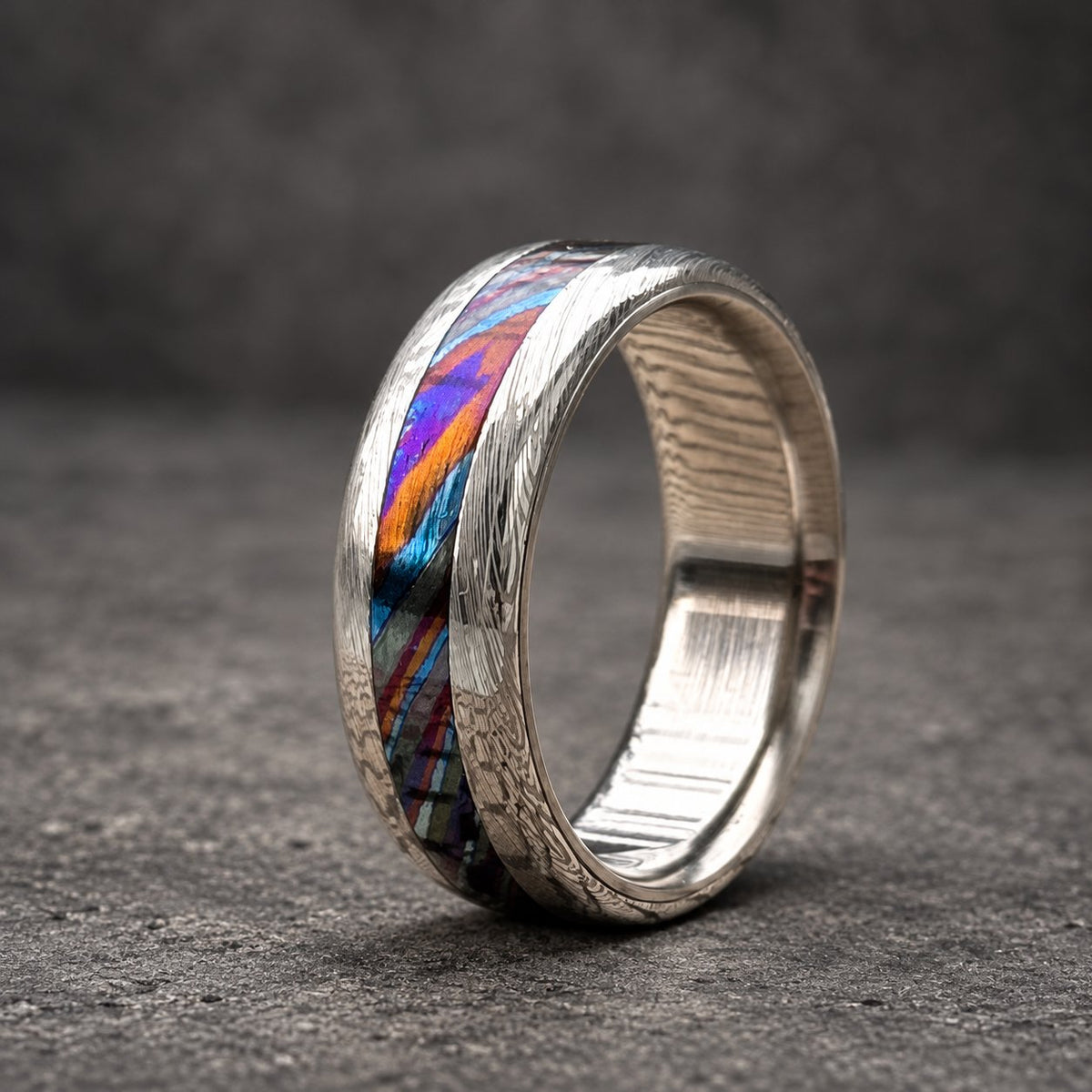 Close-up of Timascus colored inlay running through gray Damasteel band