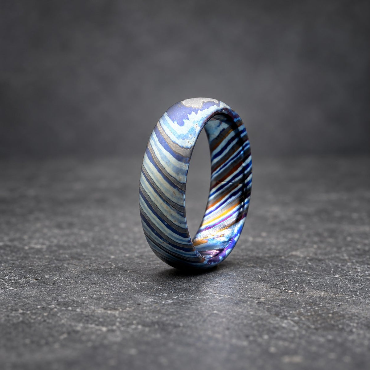 Zircoti ring photographed at an angle showing black and color layers