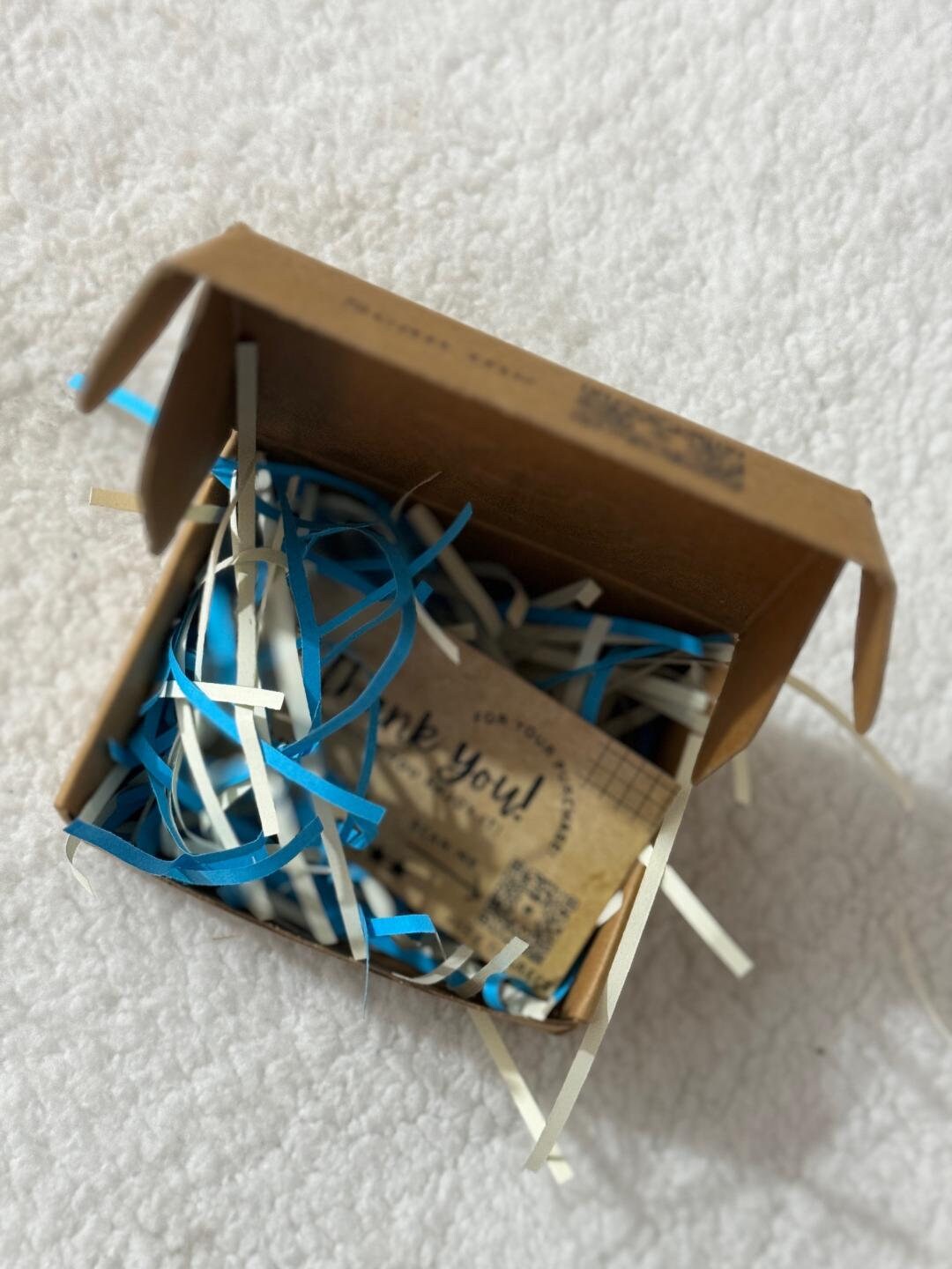 Shipping box with paper packing and a thank-you card