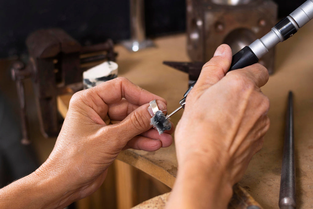 A ring being engraved by hand at the workbench
