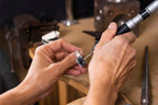 A ring being engraved by hand at the workbench