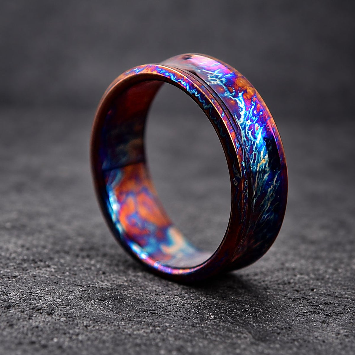 A wide, dark blue and purple ring with a textured, iridescent finish. The ring has a beveled edge and a polished interior.