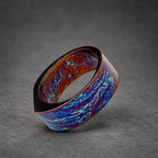 A wide, dark blue and copper ring with a swirling, marbled pattern. The ring is made of metal and has a smooth, polished finish.