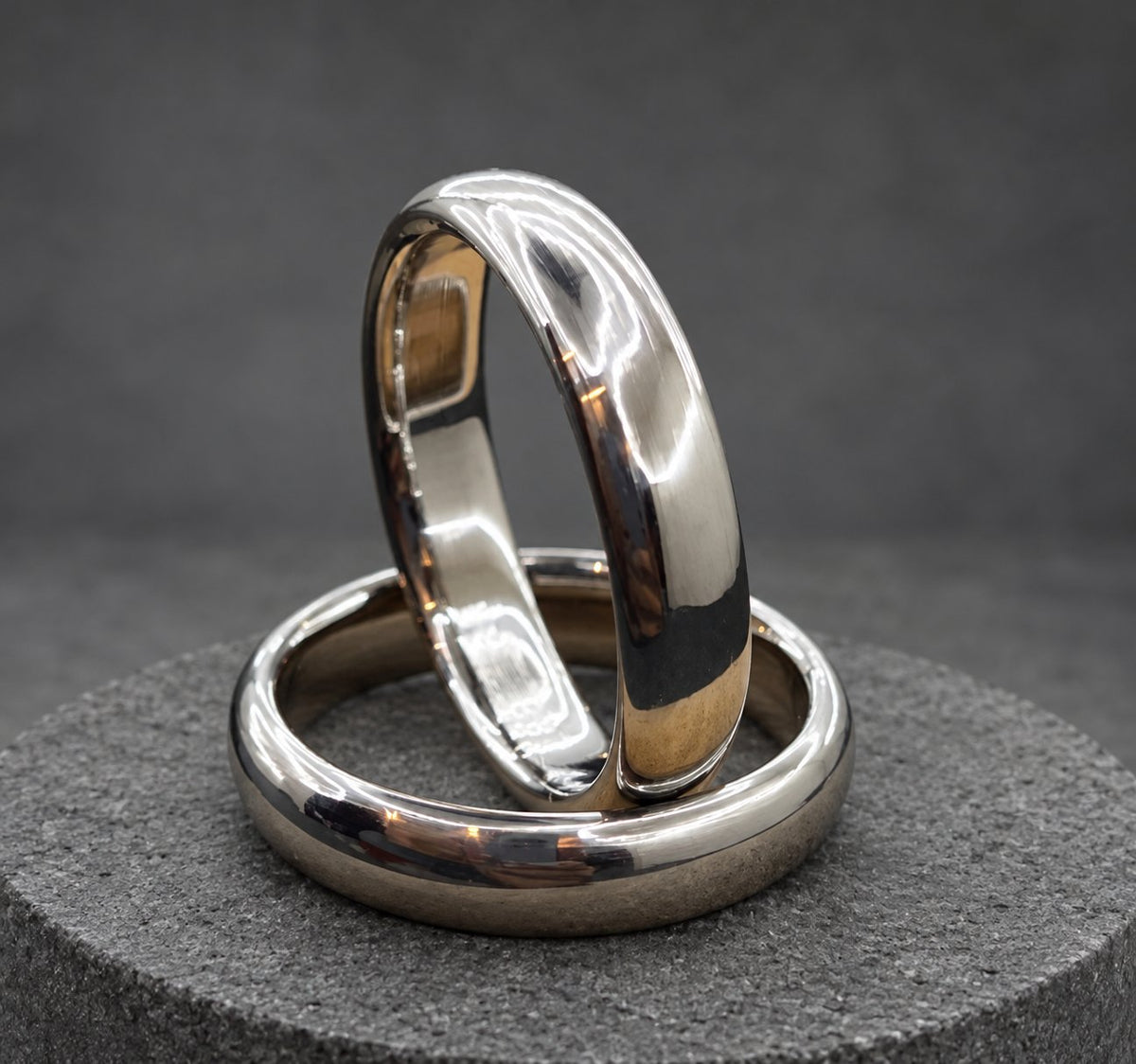Two silver wedding bands stacked on top of each other. The bands are smooth and shiny.