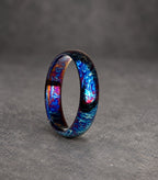 A blue, purple and red patterned metal ring. The ring is made from a durable metal and has a unique, swirling design.