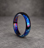 A blue, black and purple ring with a swirling pattern. The ring is made of metal and has a polished finish.