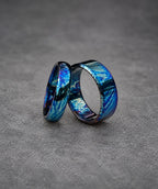 Two silver rings with a blue and purple iridescent finish. The rings are stacked on top of each other.