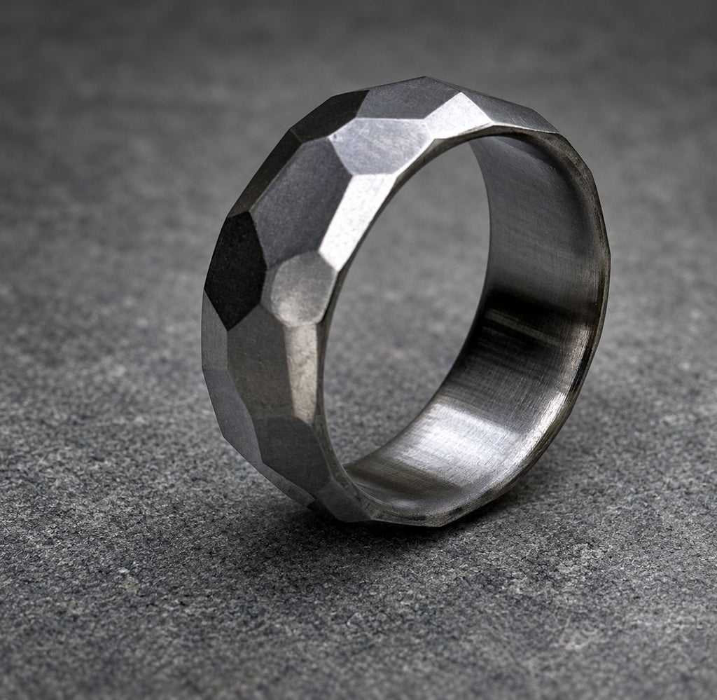 A silver ring with a textured, faceted design. The ring is made of metal and has a polished finish, view 6