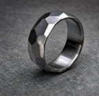 A silver ring with a textured, faceted design. The ring is made of metal and has a polished finish, view 6
