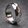 A silver ring with a geometric, faceted design. The ring is made of metal and has a brushed finish.
