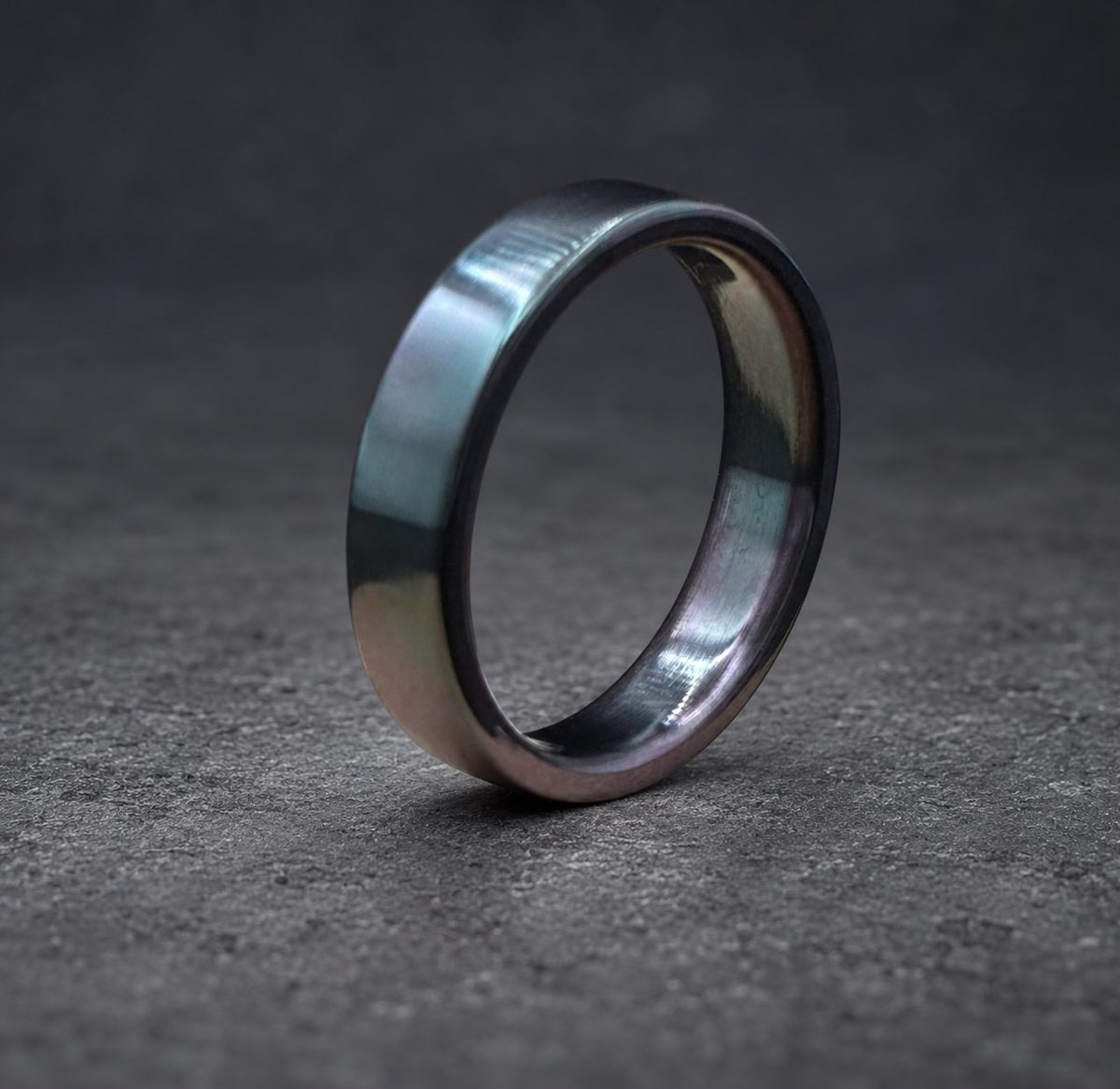 A black and silver ring with a smooth, polished finish. The ring is made of metal and has a simple, modern design.