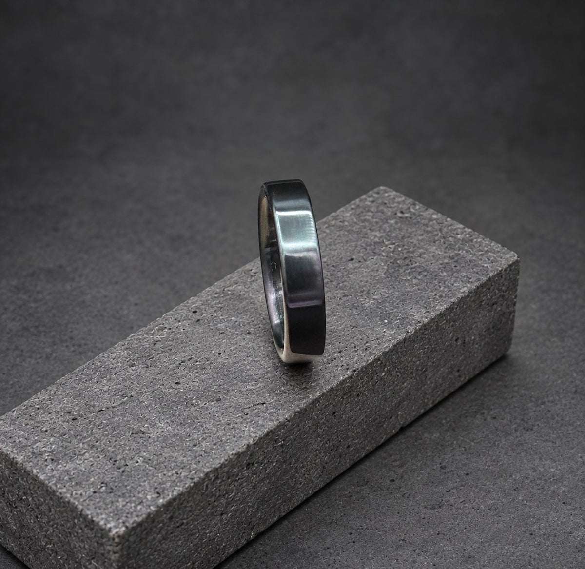 A black metal ring with a flat, polished surface.