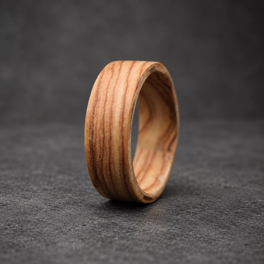 A wooden ring with a natural wood grain pattern. The ring is a light brown color and has a smooth, polished finish.