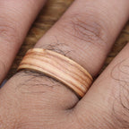 A wooden ring with a light brown wood grain pattern.