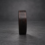 A black wooden ring with a dark brown wood grain pattern.
