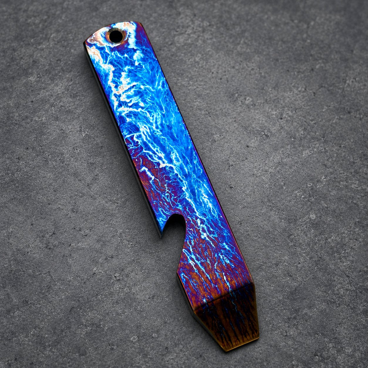 A vibrant bottle opener with a distinctive design. It displays a blue and purple lightning pattern, with a textured brown end. It has a hole for a keyring.