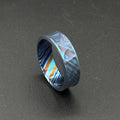 A patterned ring in shades of blue, purple, and orange. The ring's design is intricate and eye-catching, with a modern aesthetic. The ring is suitable for everyday wear or special occasions, with a unique and stylish appearance.