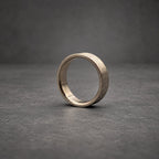 A circular ring with a metallic gray finish and a textured, brushed exterior surface. The band features a smooth, polished interior lining that contrasts with the rugged, matte appearance of the outer circumference of the ring.