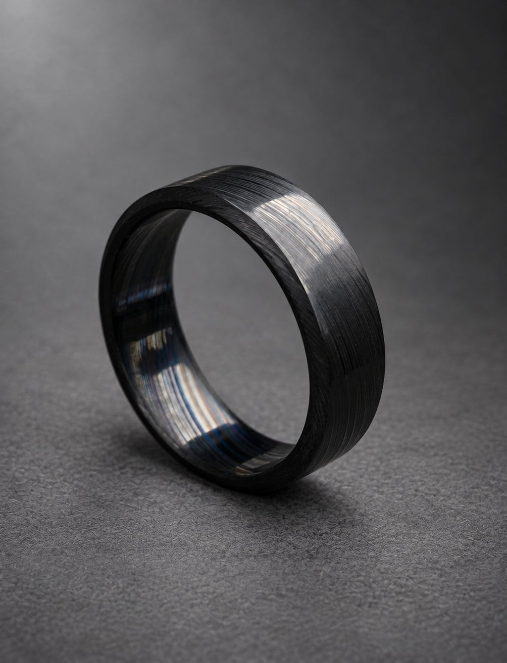 Black Damasteel band standing on its edge